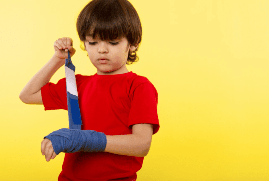 Children learning basic first aid skills by applying adhesive bandages